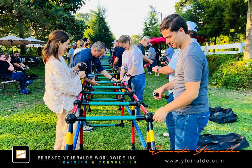 Building Bridges: Participantes construyendo puentes reales y simbólicos que reflejan cohesión y propósito en Building Bridges – Construyendo Puentes
